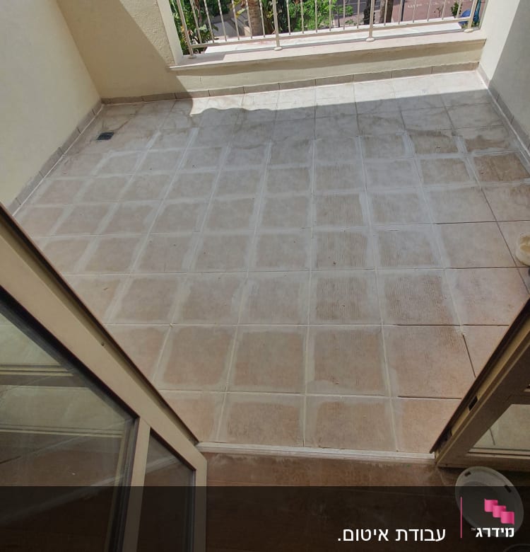 מרפסת עם רצפה מרוצפת ואדם עם בגדי עבודה